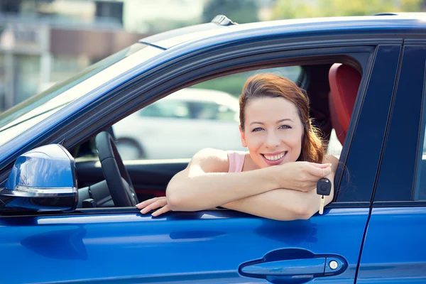 Frau sitzt in ihrem neuen Auto und zeigt Schlüssel — Stockfoto