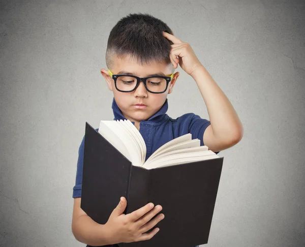 Barn med glasögon läser bok — Stockfoto