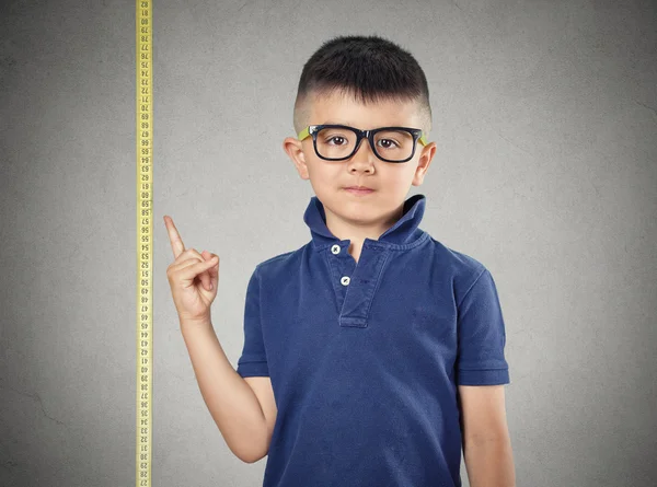 Kind wijzen op zijn hoogtepunt op meetlint — Stockfoto