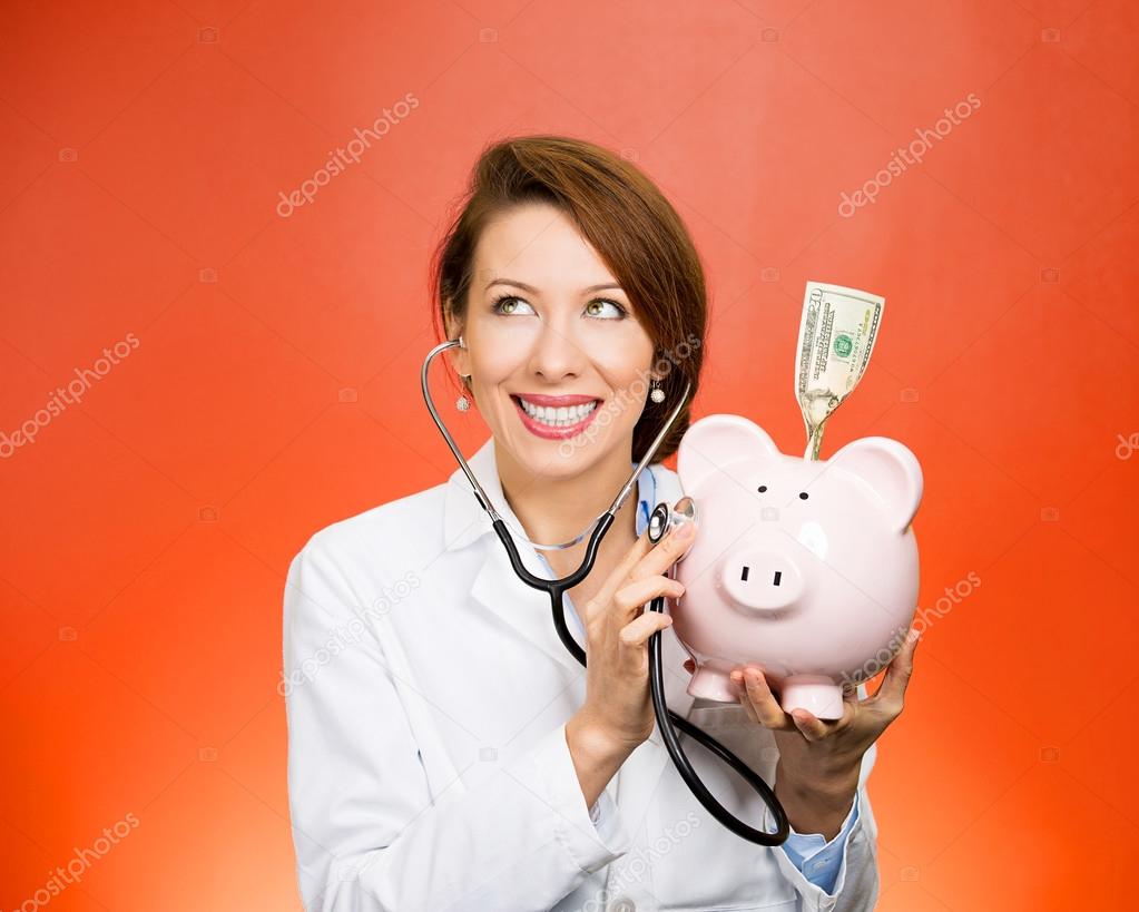 doctor listening with stethoscope to piggy bank