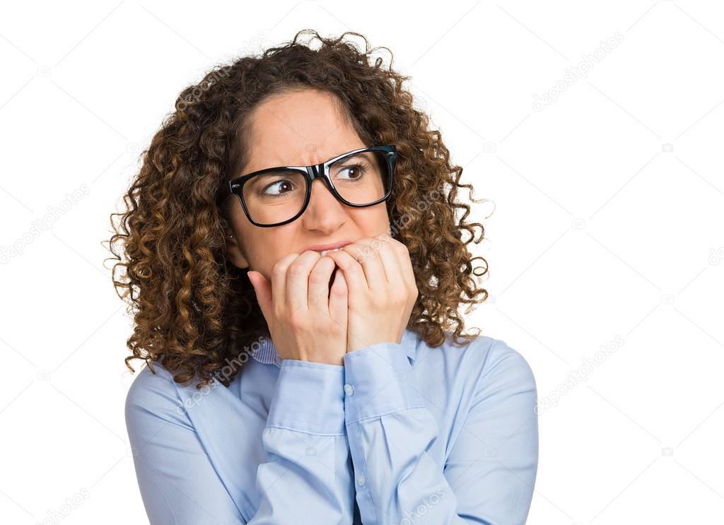 Nervous woman with glasses biting her fingernails