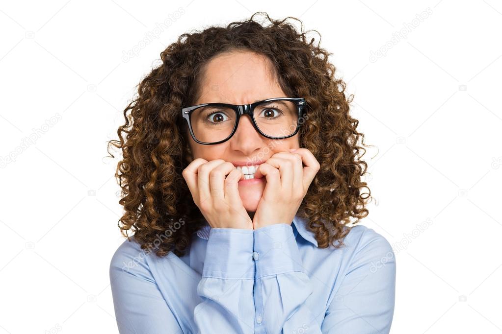 Nervous woman with glasses biting her fingernails