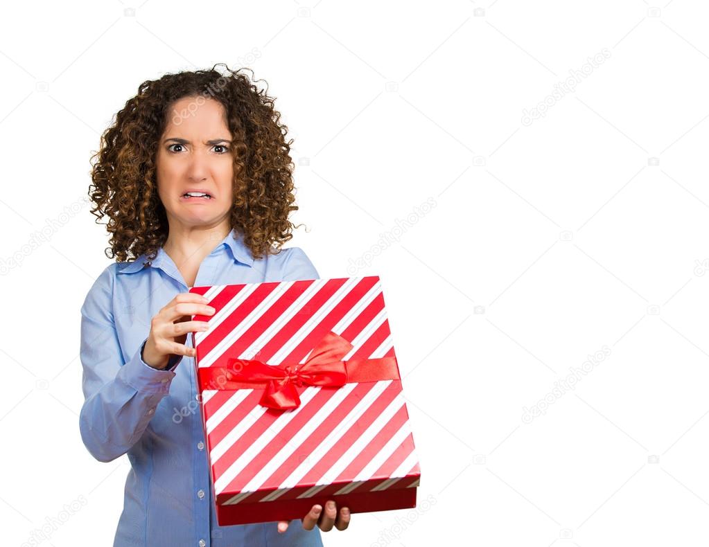 Displeased woman holding opening christmas red gift box