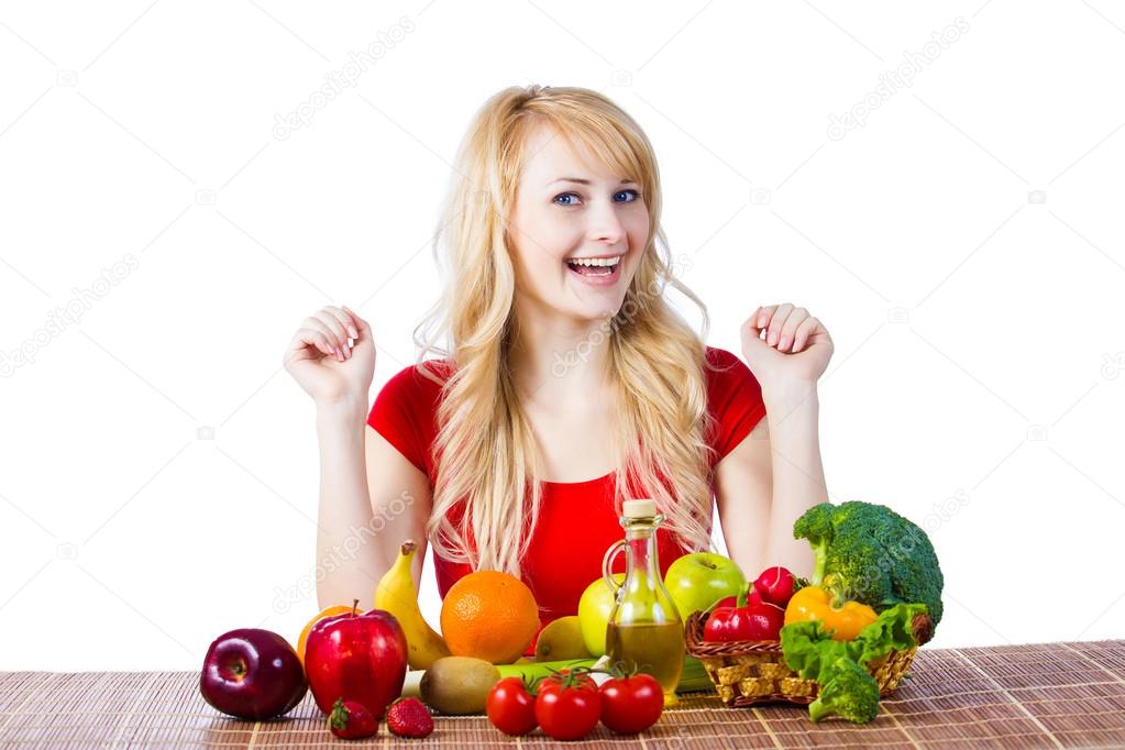 Woman sitting at table with fruits and vegetables