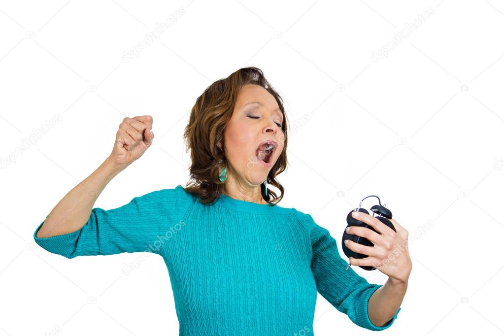 Sluggish overworked, weary, sleepy tired senior woman holding alarm clock