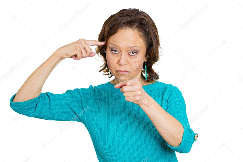 Angry senior woman, gesturing with finger against temple, are you crazy?
