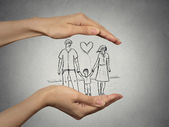 Frauenhände schützen glückliche Familie