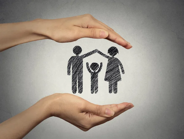 Woman's hands protecting happy family — Stock Photo, Image