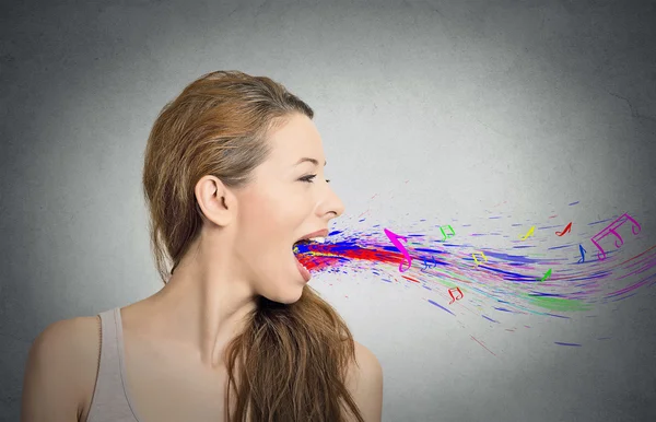 Donna che canta a bocca aperta colorate note schizzi volare via — Foto Stock