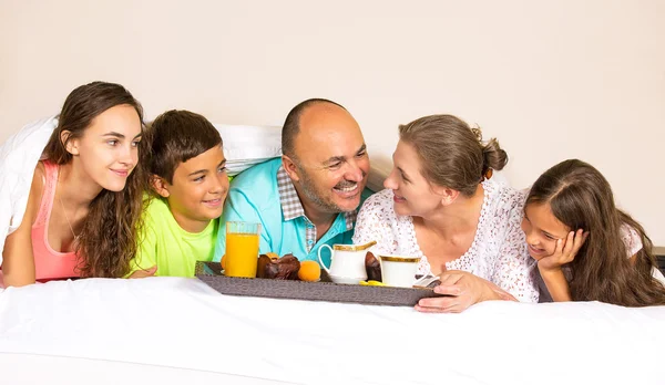 Feliz sorrindo família alegre tomando café da manhã na cama — Fotografia de Stock
