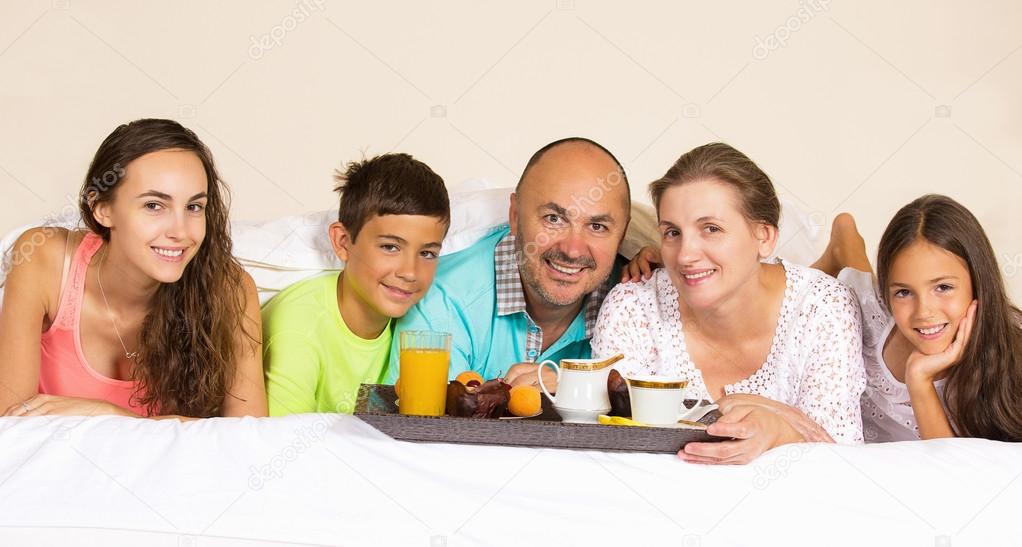 happy smiling joyful family having breakfast in bed