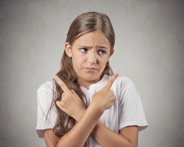 Verwirrtes Teenager-Mädchen zeigt in zwei verschiedene Richtungen — Stockfoto