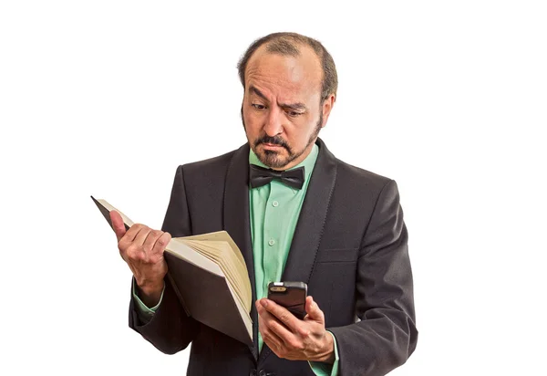 Escéptico hombre leyendo noticias en el teléfono inteligente, sosteniendo libro —  Fotos de Stock