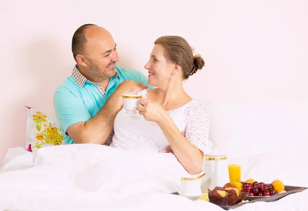 Couple prenant le petit déjeuner au lit — Photo