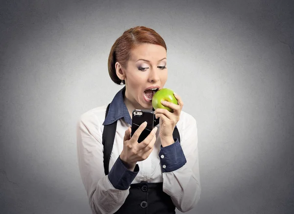 Mulher olhando para telefone inteligente comendo maçã — Fotografia de Stock