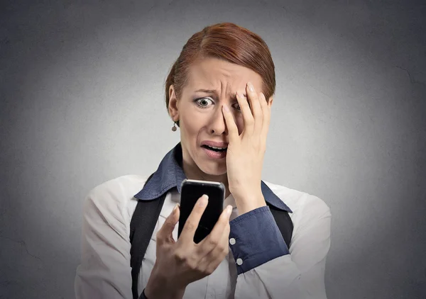 Напряженная женщина шокирована сообщением на смартфоне — стоковое фото