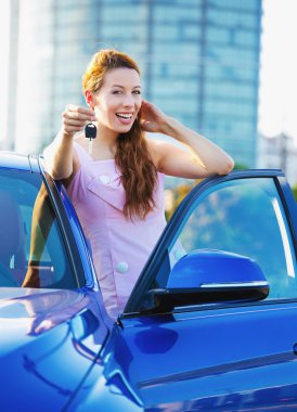 Yeni arabanın anahtarlarını gösteren kadın