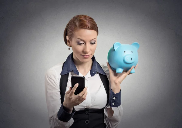Vrouw met piggy bank kijken naar slimme telefoon — Stockfoto