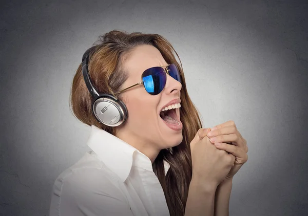 Жінка з сонцезахисними окулярами співає слухаючи музику — стокове фото