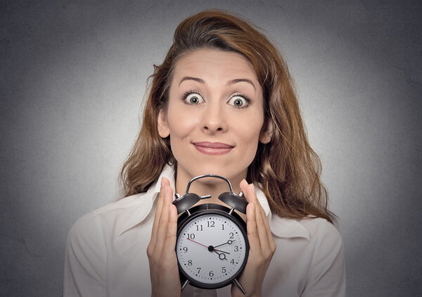 business woman holding alarm clock waiting