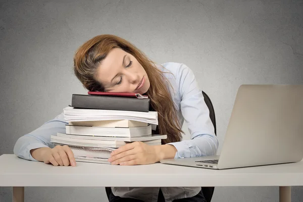 Femme dormant sur des livres à son bureau — Photo