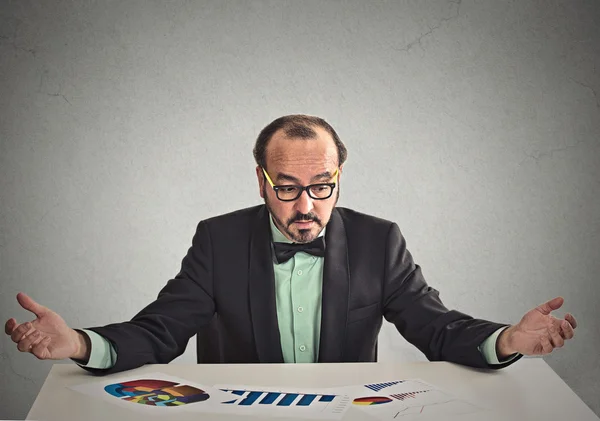 Geschäftsmann sitzt am Tisch und schaut sich Finanzberichte an — Stockfoto