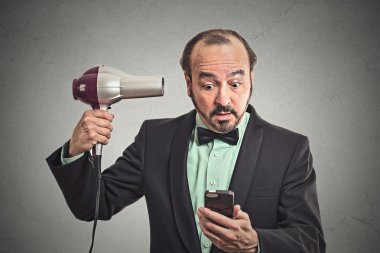 saç kurutma makinesi tutan smartphone haber okuma iş adamı