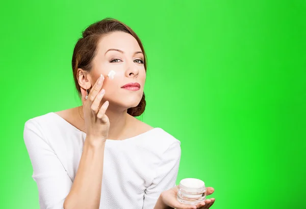 Mulher aplicando creme no rosto — Fotografia de Stock