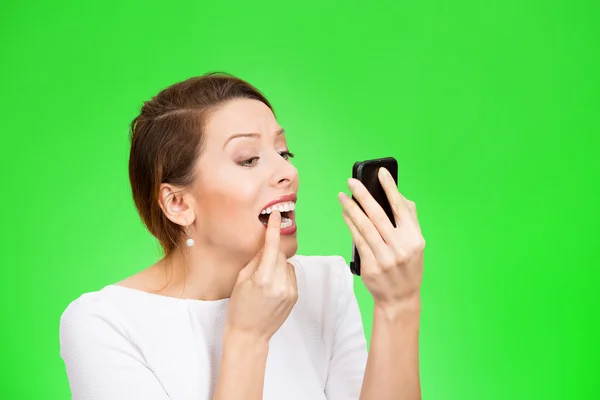 Kvinna som tittar i en spegel kontrollera hennes tänder — Stockfoto