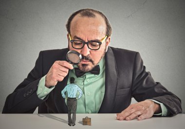Büyüteç aracılığıyla küçük çalışan bakarak işadamı
