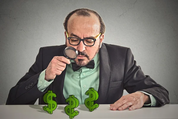 Büyüteç, dolar işaretleri bakarak iş adamı 