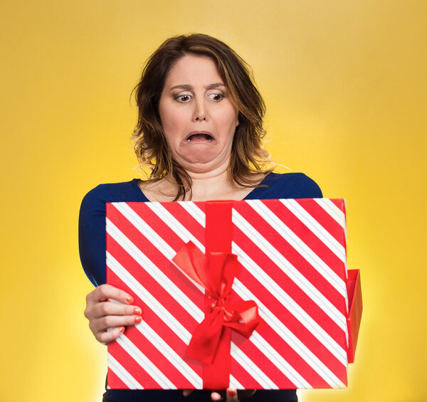 женщина открывает подарочную коробку расстроен тем, что она получила

