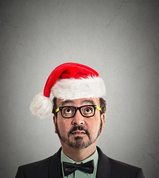 Homme de Noël avec des lunettes en chapeau santa claus rouge levant les yeux — Photo