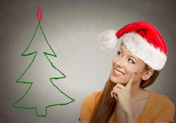 Mujer en santa helper sombrero mirando árbol de Navidad — Foto de Stock