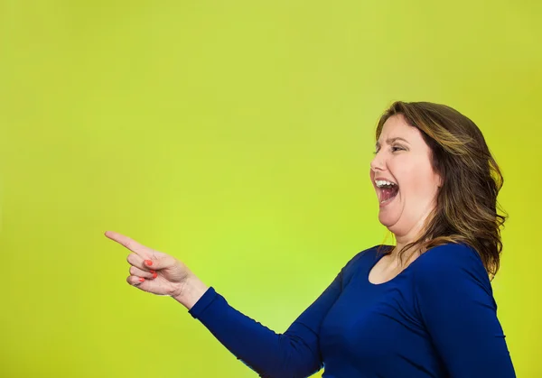 Feliz riendo mujer apuntando con el dedo a algo — Foto de Stock