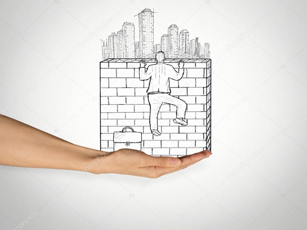 businessman climbing to the top of brick wall