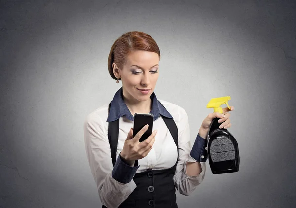 Frau hält Smartphone und Reinigungssprayflasche für Glas — Stockfoto