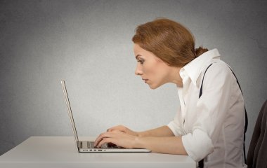 Masa başında oturan bilgisayarda çalışan kadın
