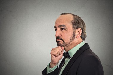 düşünceli adam dalgın bakarak merak yüz ifadesi ile