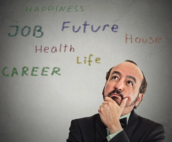 Thoughtful middle aged business man looking up thinking of life choices — Stock Photo, Image