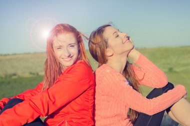 Two women smiling enjoying sunny weather blue sky nature celebrating freedom clipart