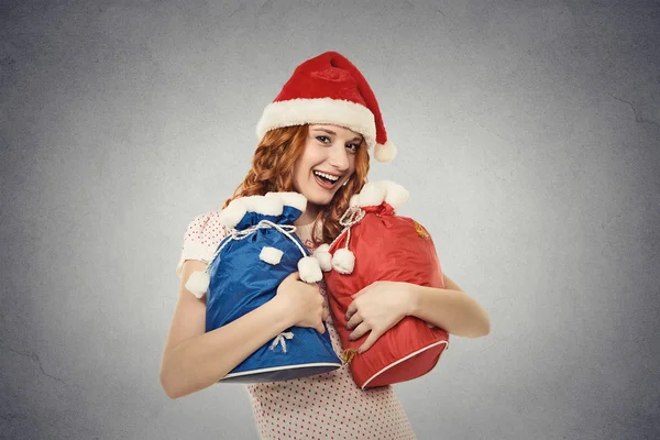 Χριστούγεννα γυναίκα με καπέλο Αϊ-Βασίλη κόκκινο κρατώντας τσάντες δώρων — Φωτογραφία Αρχείου