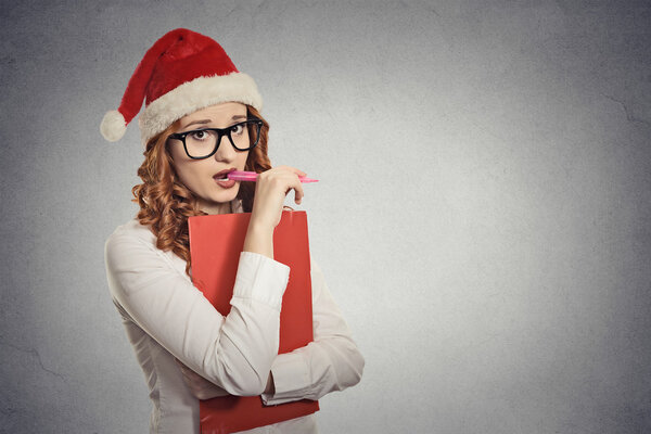 woman with christmas hat is posing in studio thinking of gift ideas 