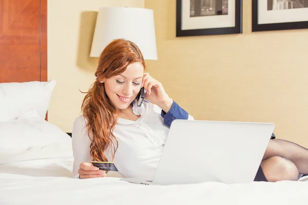 Mujer acostada en la cama con el ordenador portátil celebración de compras con tarjeta de crédito en línea — Foto de Stock