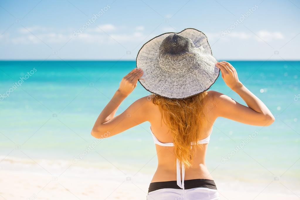 Woman enjoying beach relaxing joyful in summer by tropical blue water