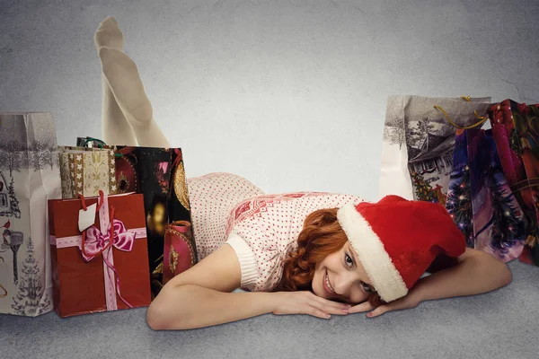 Woman in red santa claus hat with christmas gifts dreaming fun holidays — Stock Photo, Image