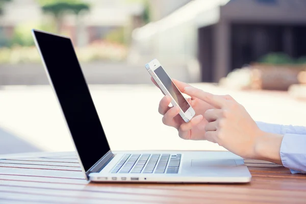 Las manos de la mujer sosteniendo, usando el teléfono inteligente, móvil y computadora — Foto de Stock