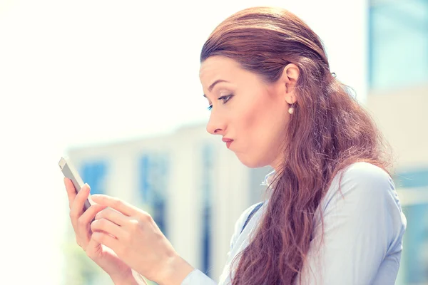 Skeptical unhappy serious woman talking texting on phone — Stock Photo, Image