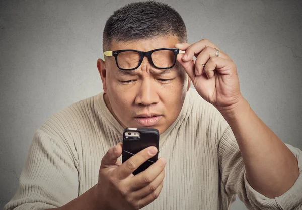 Homme avec des lunettes ayant du mal à voir les problèmes de vision d'écran de téléphone — Photo