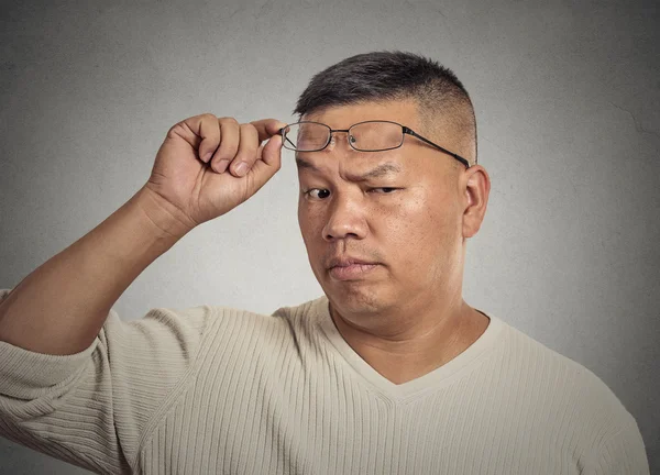 Ernster Mann mittleren Alters mit Brille, der einen skeptisch ansieht — Stockfoto